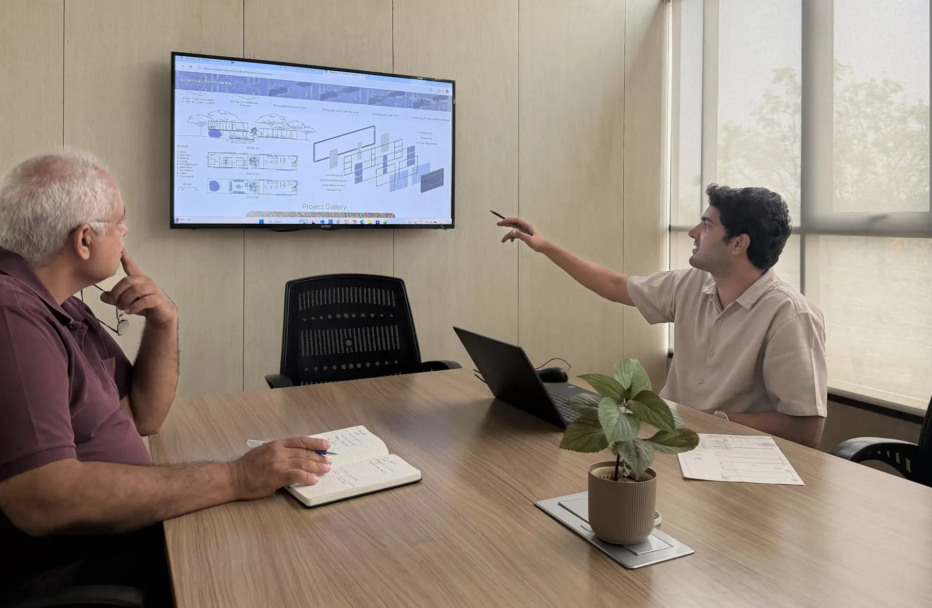 Two architects reviewing project drawings on screen in the Samani + Partners studio